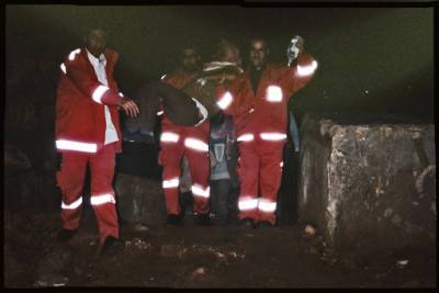 Palestinian Red Crescent EMTs carrying patient over a roadblock - Bethlehem
